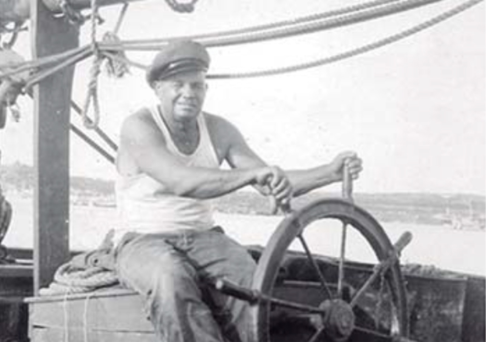 A Galician sailor at the wheel of a small vessel
